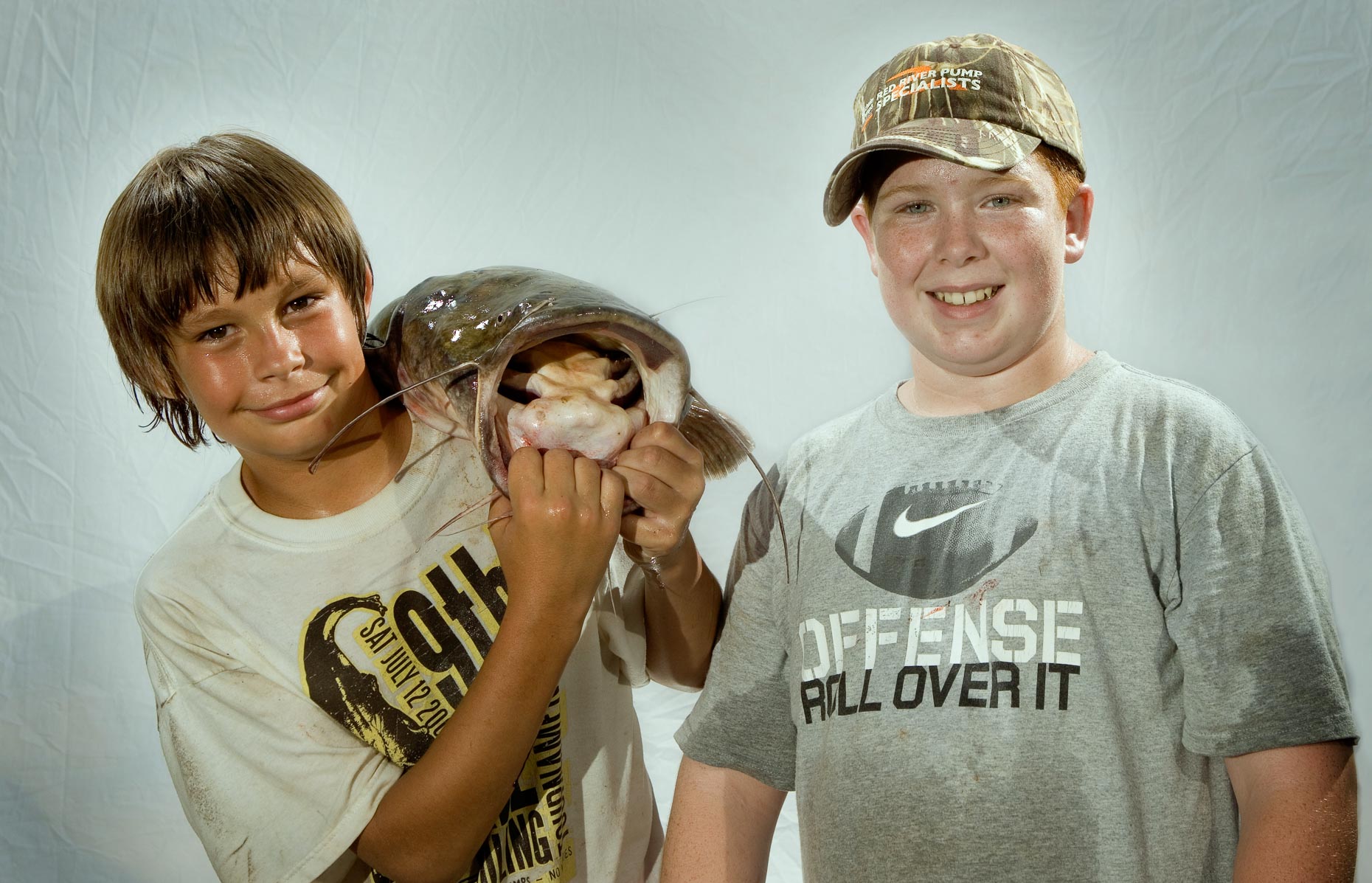 Two boys pose with a catfish during the Okie Noodling Tournament. 